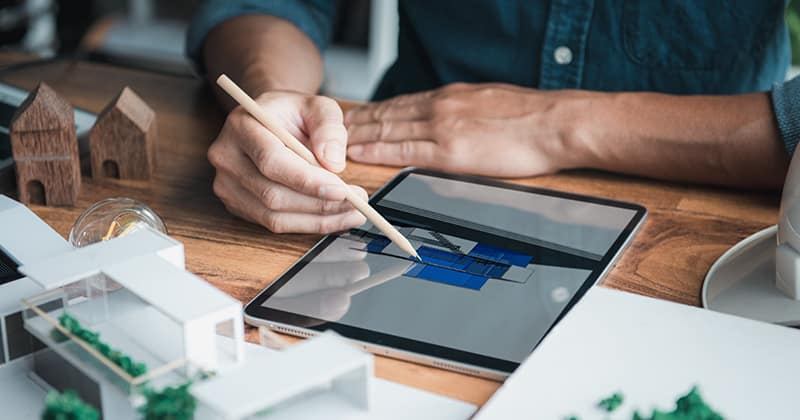 Landscape designer holding pencil and using tablet