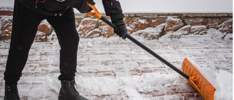 person shoveling snow off sidewalk